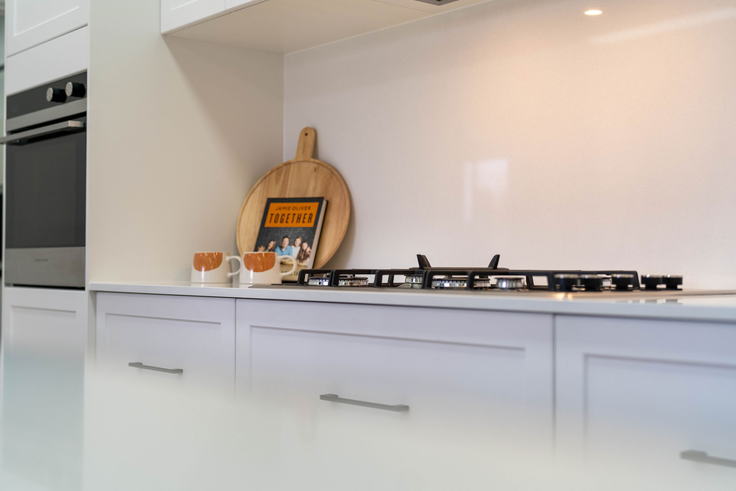 Showroom display of our Barossa cabinets with a glass white splashback