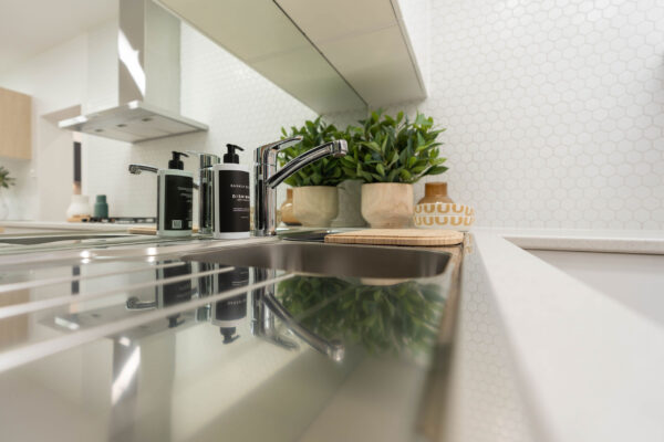 Image of a white kitchen using a mirror splashback