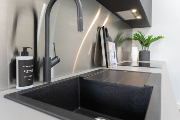 Close up image of an Oliveri black sink and black Vilo Pull Out Mixer