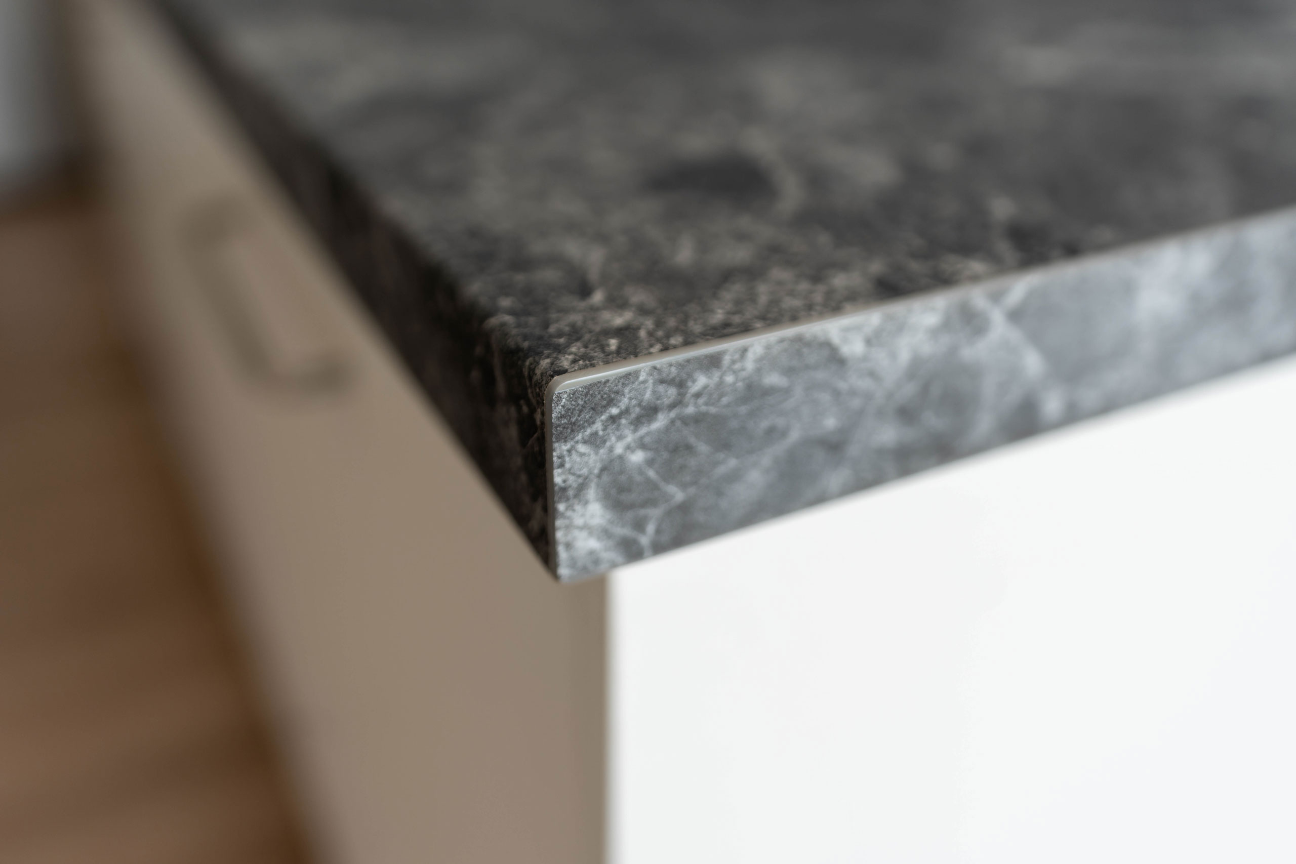 A close up image of a corner profile on a laminate benchtop