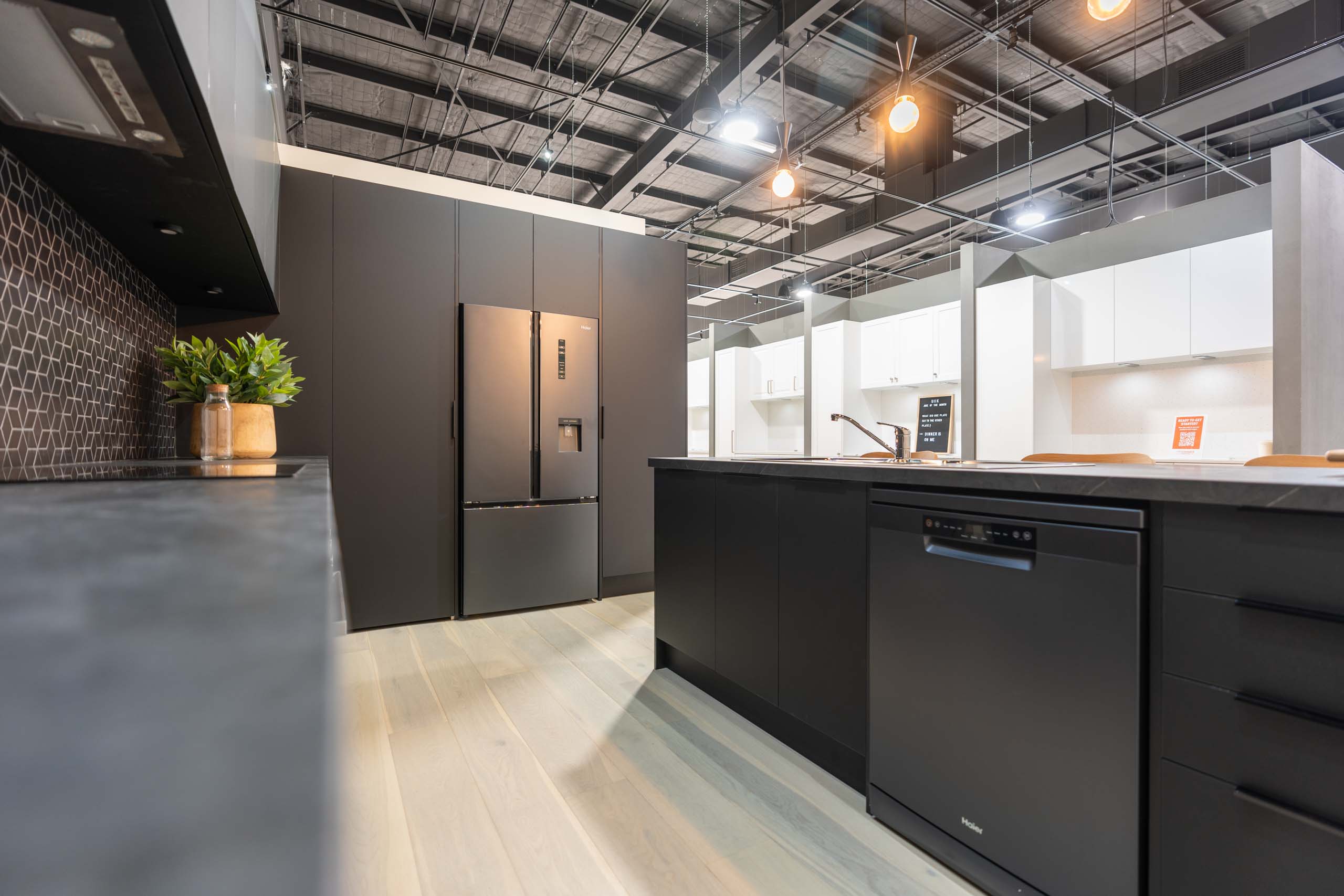 Showroom display of a Black Kitchen in our Touch range with black veined benchtops. Haier dishwasher and Haier French door fridge.