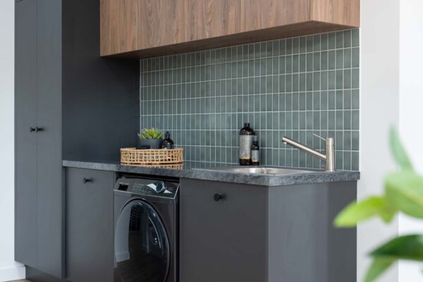 Image of U-Install-It DIY laundry renovation. Graphite cabinetry with dark timbergrain uppers and green splashback tiles