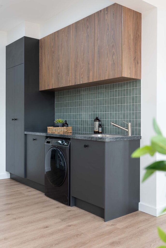 Image of U-Install-It DIY laundry renovation. Graphite cabinetry with dark timbergrain uppers and green splashback tiles
