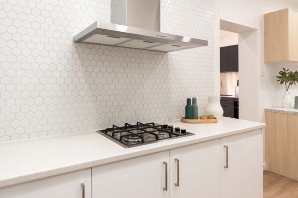 Image of Haier canopy rangehood in silver gloss kitchen with fisher & paykel gas cooktop.