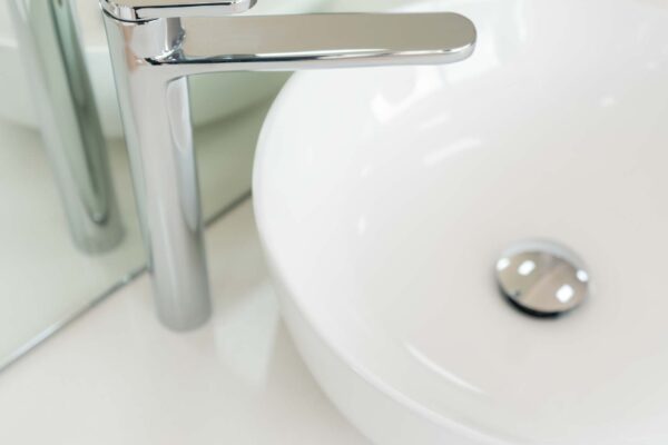 White round above the counter basin with a chrome mixer tap