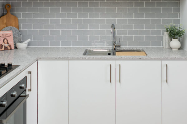 White kitchen with grey subway tiles laid in a brick bond pattern