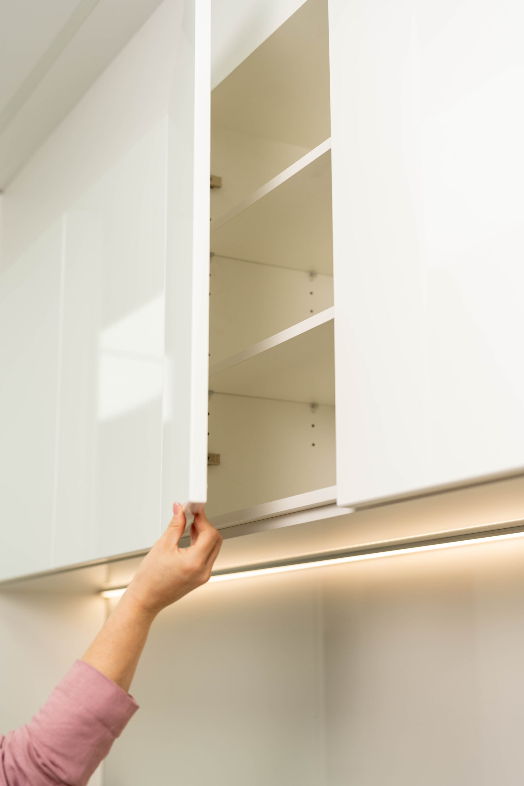 White overhead cabinetry with a handleless option for a minimalist look.