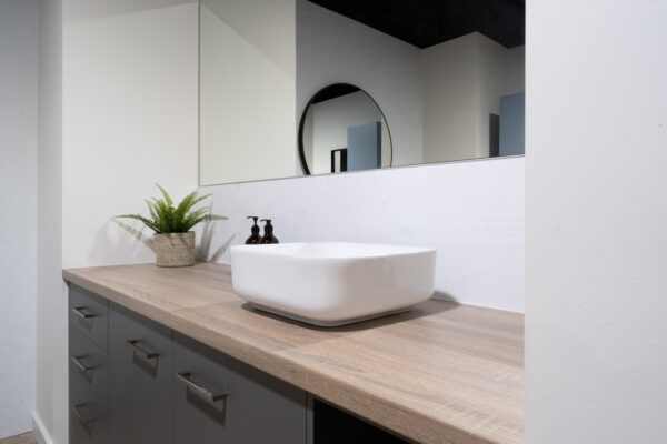 Bathroom vanity with a counter top basin and timber look benchtop with grey cabinetry